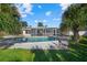 Kidney shaped swimming pool with screened enclosure and lush landscaping at 1160 Morningside Pl, Sarasota, FL 34236