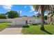 White single-story house with a garage and palm trees in the front yard at 1160 Morningside Pl, Sarasota, FL 34236