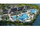Stunning aerial view of community clubhouse featuring a pool, lounge chairs, a covered dining area and landscaping at 1107 Blue Shell Loop, Sarasota, FL 34240