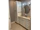 Modern bathroom featuring a granite countertop, white cabinets, vanity, and decorative mirror at 6414 Moorings Point Cir # 201, Lakewood Ranch, FL 34202