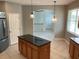 Kitchen island with granite counters, pendant lights, tile floor and stainless steel refrigerator at 6414 Moorings Point Cir # 201, Lakewood Ranch, FL 34202