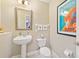 Powder room with pedestal sink, toilet, and framed artwork at 7612 Lake Vista Ct # 405, Lakewood Ranch, FL 34202