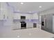 Modern kitchen with white cabinets, stainless steel appliances, and quartz countertops at 14312 Barbarossa Ln, Port Charlotte, FL 33981