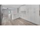 Modern kitchen with white cabinets, quartz countertops, and vinyl plank flooring at 14312 Barbarossa Ln, Port Charlotte, FL 33981