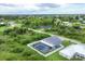 Aerial view of a house with a pool and fenced backyard in a residential area at 14312 Barbarossa Ln, Port Charlotte, FL 33981