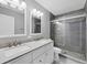 Bathroom with double vanity, white cabinets, and gray tile shower at 14312 Barbarossa Ln, Port Charlotte, FL 33981