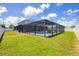 View of the backyard, showcasing a large screened pool and home at 14312 Barbarossa Ln, Port Charlotte, FL 33981