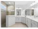 Bright bathroom featuring double sinks, tiled shower with glass enclosure and neutral color scheme at 12918 Rainwashed Loop, Parrish, FL 34219