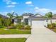 Charming single-story home featuring a well-manicured lawn, a two-car garage, and beautiful tropical landscaping at 12918 Rainwashed Loop, Parrish, FL 34219