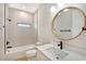 Modern bathroom with a large vanity, round mirror, and walk-in shower at 4476 Skyway Ave, North Port, FL 34288