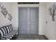 Front entry with gray double doors and striped bench at 4952 Surfside Cir, Bradenton, FL 34211