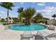 Relaxing circular pool with lounge chairs, surrounded by palm trees at 4952 Surfside Cir, Bradenton, FL 34211