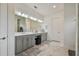 Bright bathroom boasts a double vanity with gray cabinets and marble floors at 4952 Surfside Cir, Bradenton, FL 34211
