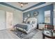 Serene main bedroom with blue accent wall, hardwood floors, and ensuite bathroom access at 4952 Surfside Cir, Bradenton, FL 34211