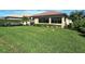Large grassy backyard with a partially visible pool and screen enclosure at 1130 Cielo Ct, North Venice, FL 34275