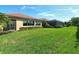 Large grassy backyard with a partially visible pool and screen enclosure at 1130 Cielo Ct, North Venice, FL 34275