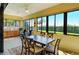 Bright sunroom with large windows, dining table and outside view at 1130 Cielo Ct, North Venice, FL 34275