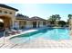 Community pool with lounge chairs and building at 1130 Cielo Ct, North Venice, FL 34275