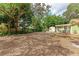 Expansive backyard with mature trees, wooden fence, and a charming deck area at 1533 1St Ave W Dr, Bradenton, FL 34205