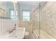 Bright bathroom featuring a sink, toilet, and marble tiled shower with glass doors at 1533 1St Ave W Dr, Bradenton, FL 34205