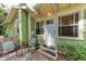 Charming front entrance with green siding, cozy seating area, and well-maintained steps at 1533 1St Ave W Dr, Bradenton, FL 34205