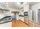Well-lit kitchen featuring stainless steel appliances, wood floors, and a view into the dining room at 1533 1St Ave W Dr, Bradenton, FL 34205