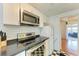 Modern kitchen featuring stainless steel appliances, checkered floors, and white cabinets at 1533 1St Ave W Dr, Bradenton, FL 34205
