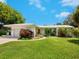 Charming single-story home boasts vibrant landscaping and a welcoming red front door at 302 Mendez Dr, Sarasota, FL 34243