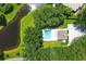 Aerial view of a pool and the surrounding landscaping and lake with lots of mature trees at 3125 57Th Avenue E Cir, Bradenton, FL 34203