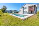 A backyard of a home with a pool, concrete decking, grass and a view of the rear of the home at 3125 57Th Avenue E Cir, Bradenton, FL 34203
