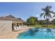 A community pool with lounge chairs and a covered area surrounded by lush landscaping and fencing at 3125 57Th Avenue E Cir, Bradenton, FL 34203