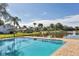 Community pool is surrounded by a black metal fence and lush landscaping with a lake view at 3125 57Th Avenue E Cir, Bradenton, FL 34203
