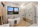 Elegant bathroom with marble walls, soaking tub, walk-in shower, and modern fixtures at 3464 Camino Real, Sarasota, FL 34239