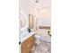 Luxurious bathroom with a modern vanity, round mirror, a bathtub-shower combo, and marble flooring at 3464 Camino Real, Sarasota, FL 34239
