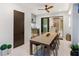 Outdoor dining area with long table, chairs, ceiling fan, and outdoor kitchen including built-in grill and beverage center at 3464 Camino Real, Sarasota, FL 34239