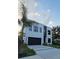 Modern two-story home with clean lines, sleek black garage door, and a well-manicured lawn at 3464 Camino Real, Sarasota, FL 34239