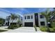 Contemporary home with a black garage door, a simple design, and fresh landscaping at 3464 Camino Real, Sarasota, FL 34239
