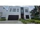 Contemporary two-story home featuring a black garage door, modern landscaping, and an inviting entrance at 3464 Camino Real, Sarasota, FL 34239