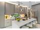 Modern kitchen with an island, pendant lights, lots of cabinetry, and stainless steel appliances at 3464 Camino Real, Sarasota, FL 34239