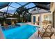 Relaxing outdoor area with a pool, jacuzzi, lounge chairs, and screened enclosure at 3464 Camino Real, Sarasota, FL 34239