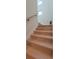 Bright staircase featuring light wood steps, white risers and walls, and a natural wood handrail at 3464 Camino Real, Sarasota, FL 34239
