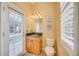 Bright bathroom with a wood vanity, granite countertop, and door leading to the pool at 4532 Shark Dr, Bradenton, FL 34208