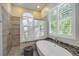 Bright bathroom with soaking tub, tiled shower, and plantation shutters at 4532 Shark Dr, Bradenton, FL 34208