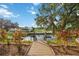 Wooden dock offers serene waterfront view of canal; lush foliage and clear blue sky enhance the tranquil setting at 4532 Shark Dr, Bradenton, FL 34208