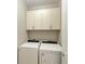 Laundry room with Whirlpool washer and dryer, and white cabinets at 17006 Hampton Falls Ter, Lakewood Ranch, FL 34202