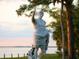A majestic marble statue of a Roman emperor, set against a serene waterfront landscape at 302 Mendez Dr, Sarasota, FL 34243