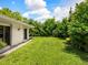 Spacious grassy backyard with mature trees, offering ample space for recreation at 302 Mendez Dr, Sarasota, FL 34243