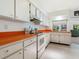 Kitchen with orange countertops and a view into the living room at 302 Mendez Dr, Sarasota, FL 34243