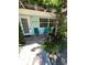 Charming front patio featuring teal chairs, a small table, and lush greenery at 1603 Gulf N Dr # 5, Bradenton Beach, FL 34217