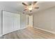 Bedroom with wood-look floors, ceiling fan and double doors to closet at 515 30Th W Ave # H201, Bradenton, FL 34205